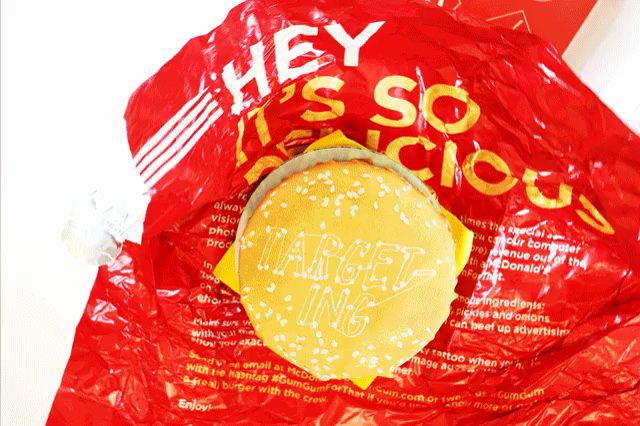 A burger in a red wrapper printed with the words Hey, it's so delicious.